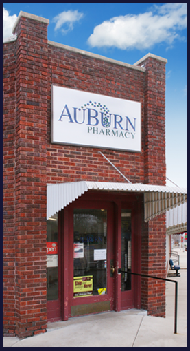 Pictured is The AuBurn Pharmacy Wellsville Kansas Location. This is a all brick building with a large glass door.